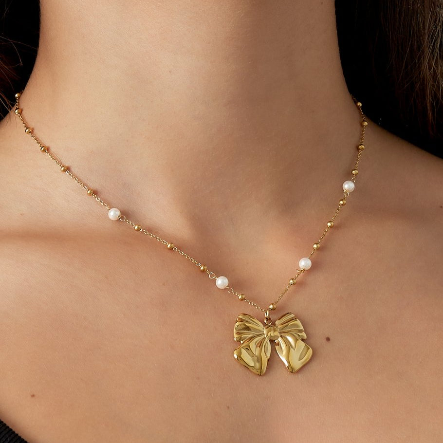 Gouden ketting met strikhanger en pareldetails